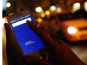 In this photo illustration, a woman uses the Uber app on an Samsung smartphone on Sept. 2, 2014.