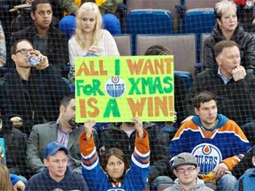 A fan tired of losing holds up a sign during an Arizona Coyotes and Edmonton Oilers game Dec. 23, 2014, at Rexall Place.