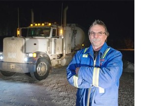 Truck driver Ed Sullivan stands with his fuel truck after delivering diesel in Fort Chipewyan.