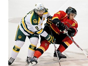 University of Alberta Golden Bears’ Johnny Lazo, left, checks Calgary Dinos’ Colton Grant during Game 1 of the Canada West final action at the University of Alberta on Thursday, March 5, 2015. The Bears swept the Dinos with a 2-1 victory in Game 2 on Friday.