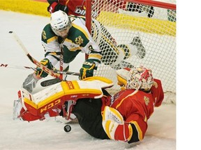 University of Alberta Golden Bears Johnny Lazo received a goaltender interference penalty on this play after colliding with Calgary Dinos goalie Kris Lazaruk during Canada West men’s hockey final game action at the University of Alberta in Edmonton on March 5, 2015.