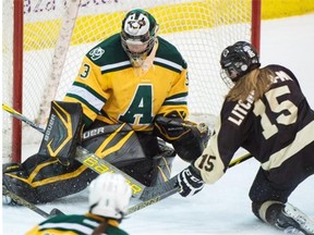University of Alberta Pandas goalie Lindsey Post makes a save with Manitoba Bisons’ Maggie Litchfield-Medd in front during Game 1 of the Canada West final at Clare Drake Arena on Friday, March 6, 2015. The Pandas swept the Bisons with a Game 2 victory on Saturday.