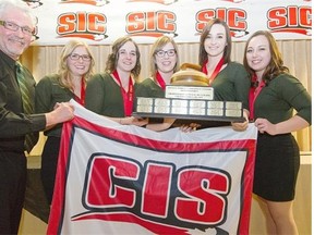 University of Alberta Pandas skip Kelsey Rocque, right, poses with the Canadian Interuniversity Sport women’s curling championship trophy and banner along with her team of, from left, coach Garry Coderre, Taylore Theroux, lead Claire Tully, second Allison Kotylak and third Taylor McDonald.