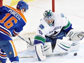 Vancouver Canucks goalie Ryan Miller (30) makes the save on Edmonton Oilers’ Teddy Purcell (16) during second period NHL hockey action in Edmonton on Nov. 19, 2014.
