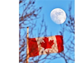 A waxing gibbous moon, about 93 per cent full, rises over the Canadian flag flying on the bell tower of the Strathcona Fire Hall No. 1  in Edmonton on March 2, 2015.