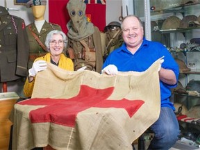 Wendy Lugg, artist-in-residence at the Royal Western Australian Historical Society, and Doug Buhler, amateur military historian and collector from Edmonton, with his historic Red Cross flag placed by Australian troops in the beach at Gallipoli during the First World War.