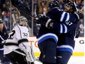 Winnipeg Jets’ Andrew Ladd (16) and Michael Frolik (67) celebrate after Ladd scored his second goal of the game against the Los Angeles Kings’ goaltender Jonathan Quick (32) during second period NHL hockey action in Winnipeg on March 1, 2015.