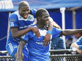 Lance Laing celebrates his fourth goal of the season with FC Edmonton teammate Kareem Moses during the second half of Sunday’s North American Soccer League game Aug. 24, 2014, against the Fort Lauderdale Strikers at Clarke Field.