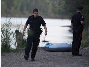After a man was found face down and unresponsive in the North Saskatchewan River police speak to some of the man’s friends at the Laurier boat launch on May 21, 2015, in Edmonton.