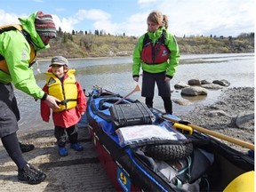 Benoit Gendreau-Berthiaume and his wife Magali Moffatt start out with their son Mali for Montreal on their cross-country canoe trip at the Capilano Boat Launch in Edmonton on Saturday.