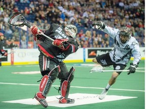 Calgary Roughnecks goalie Frankie Scigliano takes out Jarrett Davis of the Edmonton Rush during a National Lacrosse League game at Rexall Place on April 11, 2015.