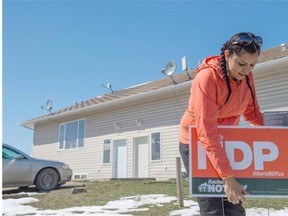 NDP candidate Katherine Swampy places a campaign sign on the Ermineskin reserve.