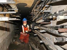 Chris Ross, a Telus cable repair access technician, inspects an underground cable vault tunnel in downtown Edmonton. The cables in this tunnel are used for telephone, Internet and data. Underground utility vaults along streets where the new Valley Line LRT will run are being relocated.