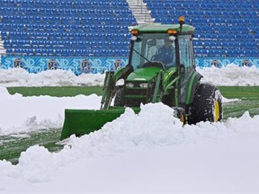 City crews clear snow from Clarke Field on Wednesday. The first leg in an Amway Canadian Championship series between FC Edmonton and the Vancouver Whitecaps was postponed because of the weather conditions.