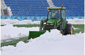 City crews clear snow from Clarke Field on Wednesday. The first leg in an Amway Canadian Championship series between FC Edmonton and the Vancouver Whitecaps was postponed because of the weather conditions.