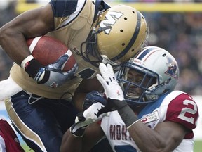 Winnipeg Blue Bombers' Cory Watson, left, is tackled by Montreal Alouettes' Mike Edem during first half CFL football action in Montreal, Monday, October 14, 2013. THE CANADIAN PRESS/Graham Hughes