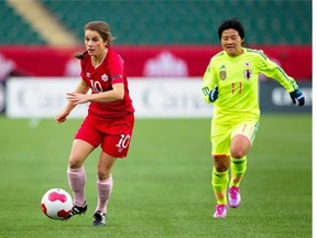 EDMONTON, ALBERTA: OCTOBER 25, 2014 ñ Jessie Fleming of Team Canada carries the ball away from Shinobu Ohno of Team Japan while playing at Commonwealth Stadium on Oct. 25, 2014. Topher Seguin/Edmonton Journal