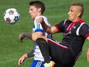 FC Edmonton’s Daryl Fordyce, left, and Ottawa Fury FC’s Maykon fight for the ball at Commonwealth Stadium in Edmonton on July 13, 2014.