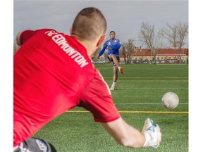 FC Edmonton’s Kareem Moses practises a penalty shot on goalkeeper Matt VanOekel during Tuesday’s practice at Clarke Field.