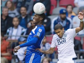 FC Edmonton’s Lance Laing gets his head on the ball while being challenged by Vancouver Whitecaps’ Ethen Sampson during Wednesday’s Amway Canadian Championship semifinal soccer game at Vancouver on May 13, 2015.