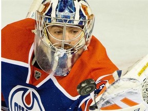 Edmonton Oilers goalie Richard Bachman juggles the puck after stopping a shot in a National Hockey League game against the Dallas Stars at Rexall Place on March 27, 2015.