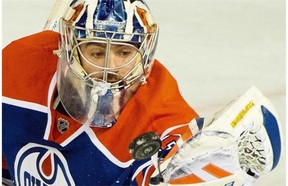 Edmonton Oilers goalie Richard Bachman juggles the puck after stopping a shot in a National Hockey League game against the Dallas Stars at Rexall Place on March 27, 2015.