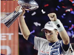 New England quarterback Tom Brady holds up the Vince Lombardi Trophy after the Patriots defeated the Seattle Seahawks in Super Bowl XLIX at Glendale, Ariz.