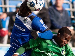 FC Edmonton's Horace James tries to head the ball past New York Cosmos Danny Mwanga at Clarke Stadium on September 28, 2014 in Edmonton.