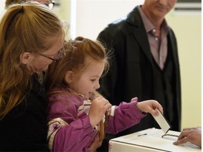 Five-year-old Jasmine Wronko helps her mom Cheri Harris vote in the advance poll at Edmonton’s McKernan Community Hall on April 29, 2015.  Graham Thomson urges readers to ignore the polls and vote for their own reasons.