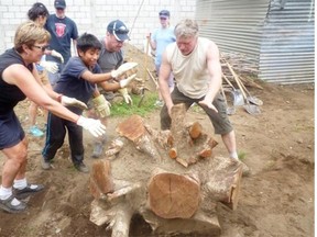 Flaman Foundation volunteers, from left, Kate Flaman, a local youngster and Pavel Madacky push tree roots out of the way while helping build a village cooperative in Santiago Panabaj, Quatemala.