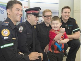 Four-year-old Talon Smith-Nelson on Wednesday met some of the people who helped save his life when he was born prematurely. From left, paramedic Robin Thenu, Edmonton police officer and former paramedic Seth Dodman, Talon, paramedic Brendan Mulholland and paramedic Sean Vesak.