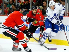 From left, Chicago Blackhawks defencemen Duncan Keith and Brent Seabrook battle for the puck with Toronto Maple Leafs forward Josh Leivo during NHL action on Oct. 19, 2013, in Chicago.