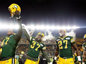 From left, Eddie Steele, Otha Foster and Mike Dubuisson celebrate the Edmonton Eskimos’ win over the Saskatchewan Roughriders in the Canadian Football League’s West Division semifinal at Commonwealth Stadium on Nov. 16, 2014.