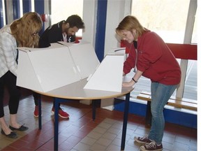 From left: Students Renee Ouellette, Jaylin January and Hannah Feddema vote at W.P. Wagner High School on May 5, 2015. On Student Vote Day, students take on the roles of election officials and organize a parallel vote identical to the official election process.