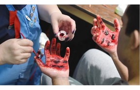 “Injured” volunteer Chris Dao gets made up with gory-looking wounds by Casualty Simulator Liz Richards, as 12 teams from across Alberta competed at the St. John Ambulance Provincial First Aid competition.