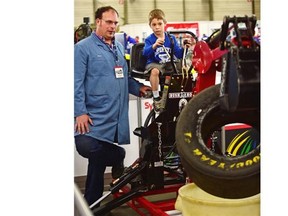 Jack Green, 7, tries his skill on a mini training excavator watched by NAIT heavy equipment instructor James Squire at the 23rd Provincial Skills Canada Competition that features high school and post-secondary students from across Alberta, competing in trade and technical events at Expo Centre in Edmonton, May 13, 2015.