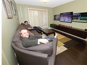 Jordan Garner (front) and roommate Morris Lo in the living room of their shared condo located in the southeast Edmonton community of Summerside.