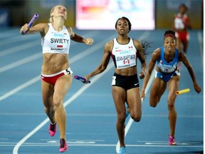 Justyna Swiety of Poland and Canada’s Audrey Jean-Baptiste, right, cross the finish line during the first round of heats in the women’s 4x400-metre relay at the IAAF World Relays at Thomas Robinson Stadium in Nassau, Bahamas, on May 2, 2015.