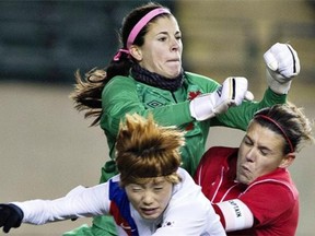 Korean Republic's Ga Eul Jeon (9) and Canada's Christine Sinclair (12) crash into goal keeper Stephanie Labbe (21) during second half action of the Women's International friendly soccer match in Edmonton, Alta., on Wednesday October 30, 2013. THE CANADIAN PRESS/Jason Franson