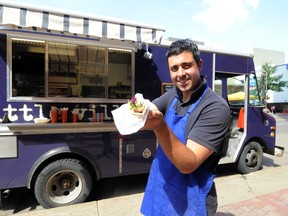 Theo Psalios and one of his soulavaki on a pita combos at Little Village Food Truck in Edmonton.