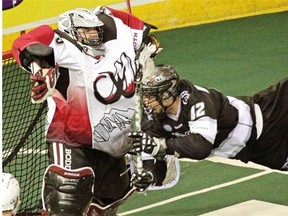 Mark Matthews of the Edmonton Rush dives across in front of the Colorado Mammoth net in an attempt to score on goalie Dillon Ward during a National Lacrosse League game at Rexall Place on April 18, 2015.