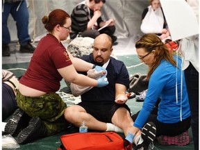 Members of 15 Field Ambulance, Canadian Forces from Edmonton Garrison work on “injured” volunteers, as twelve teams from across Alberta competed at the St. John Ambulance Provincial First Aid competition at the Delta Hotel South in Edmonton on Saturday May 2, 2015. Teams work to manage the scene and treat casualties, who are volunteers dressed in sometimes gory wounds.