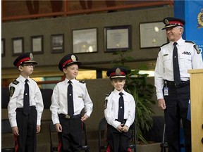 Edmonton Police Service Chief Rod Knecht presides over a special swearing-in ceremony as three children with cancer, Atticus Paine (left), Oaklin Litchfield (centre) and Lalla-Rita Hachim (right) were sworn in as Chiefs for a Day on May 19, 2015, in Edmonton. After the swearing-in, the new 'Chiefs' accompanied Chief Knecht on an official inspection of the troops.