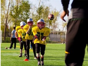 Participants in the Edmonton Eskimos’ amateur football camp work on their receiving skills at Clarke Field on May 11, 2015.