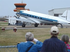 People watch a Second World War vintage DC-3 taxi to the runway, flown by the Kingdom Air Corps, at the Villeneuve Airport.