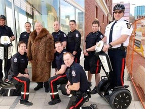 Retired Sgt. Harry Surcon, poses in a buffalo coat with current downtown police officers on May 8, 2015, on the same corner where a photograph was taken of Surcon at a call box in 1963.