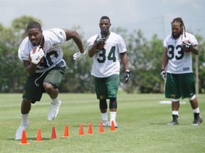 Running back Shakir Bell runs through a footwork drill while Jeremy Hold (34) and Jamal Berry (33) watch during the Edmonton Eskimos’ mini-camp at Historic Dodgertown in Vero Beach, Fla., on April 19, 2015.