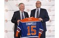 Edmonton Oilers CEO Bob Nicholson (left) and new president and general manager Peter Chiarelli (right) hold up an Oilers jersey with Chiarelli's name after he joined the team on April 24, 2015.