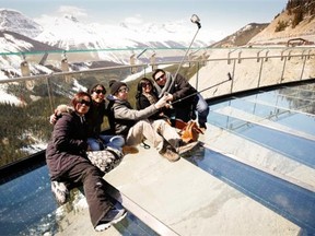 Tourists take selfies with the views from the newly opened Glacier Skywalk, run by Brewster, near the Columbia Icefields in Jasper National Park, Alta., Wednesday, May 7, 2014.