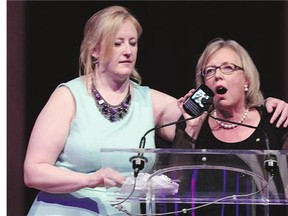Transport Minister Lisa Raitt, left, prompts Green Party Leader Elizabeth May to stop her speech at the Annual Parliamentary National Press Gallery Dinner in Ottawa Saturday.